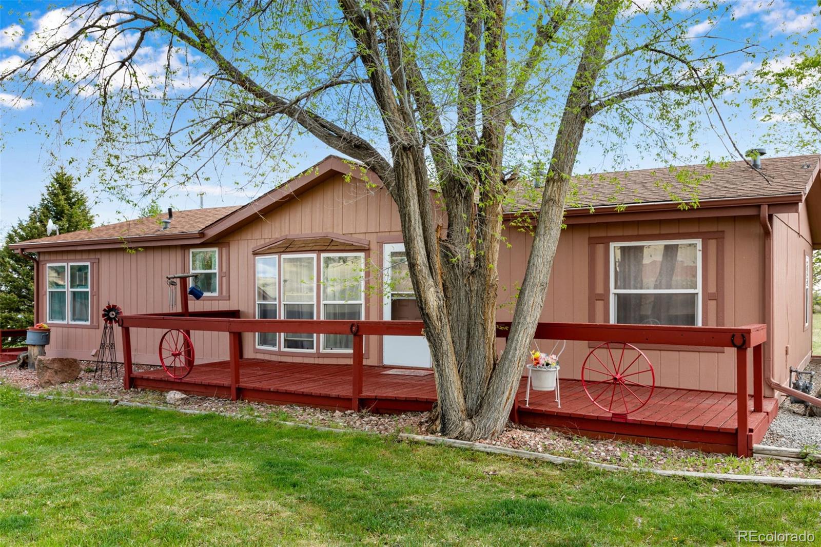6310 West Co Road 4 Berthoud, CO 80513 - Photo 12 of 49 a view of backyard with a table and chairs and a large tree