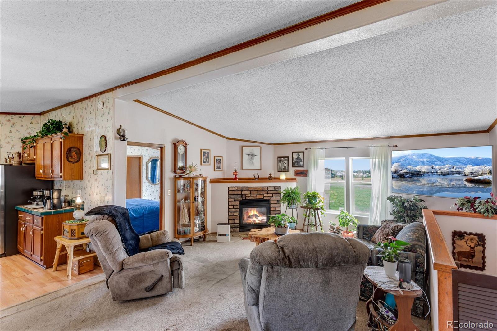 6310 West Co Road 4 Berthoud, CO 80513 - Photo 16 of 49 a living room with furniture a fireplace and a floor to ceiling window