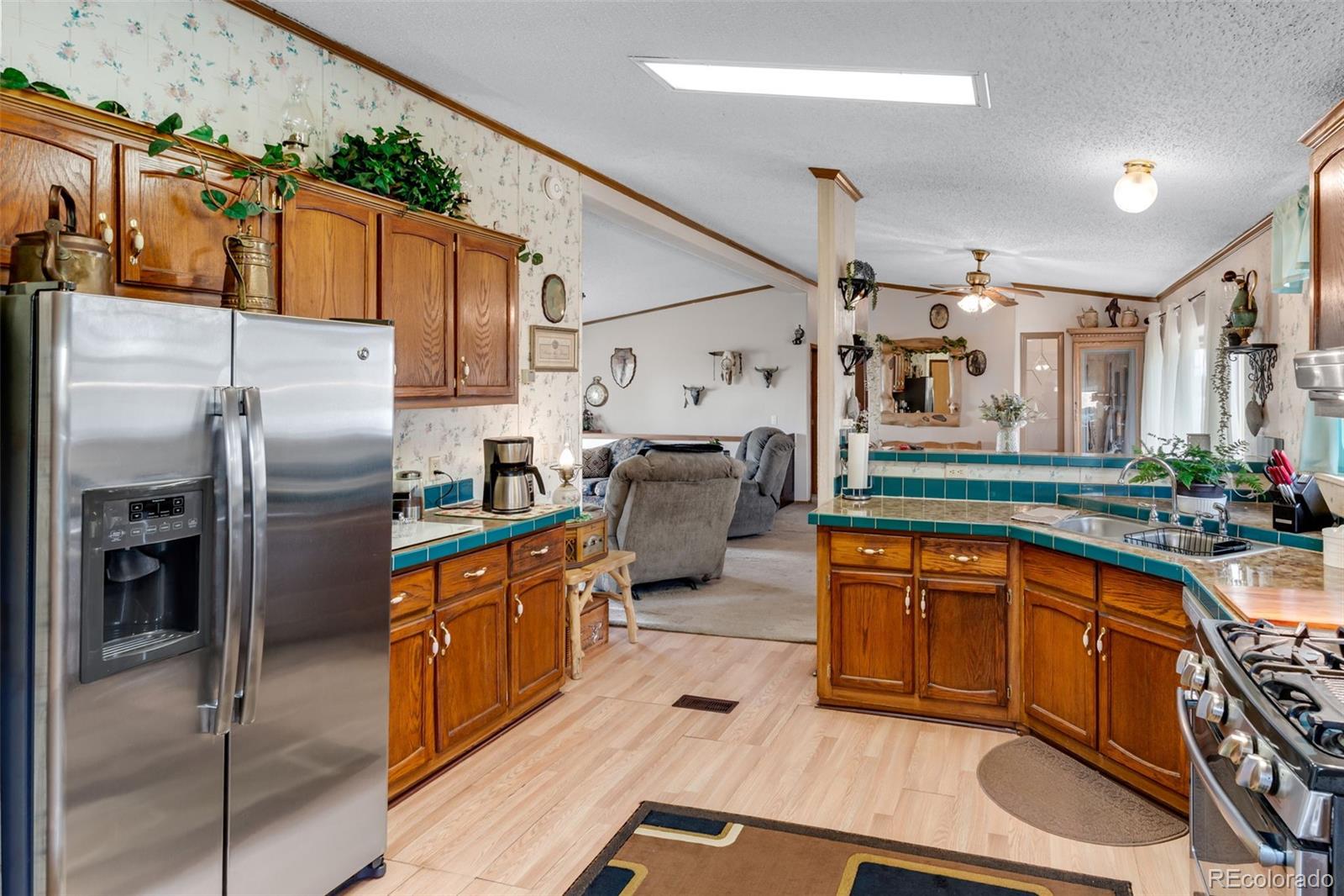 6310 West Co Road 4 Berthoud, CO 80513 - Photo 17 of 49 a kitchen with stainless steel appliances a refrigerator a sink and white cabinets