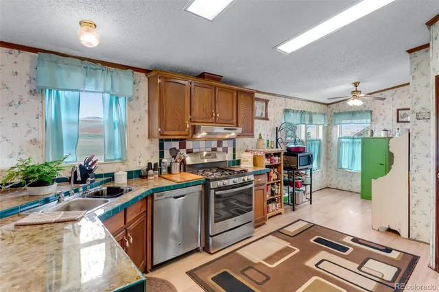 a kitchen that has a lot of cabinets a sink and a stove in it
