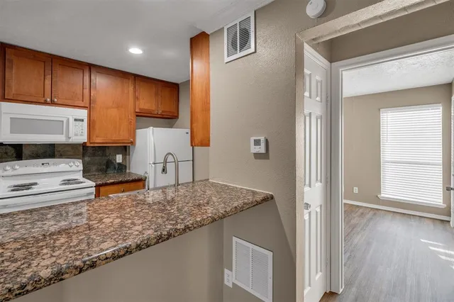 a kitchen with stainless steel appliances granite countertop a sink stove and cabinets