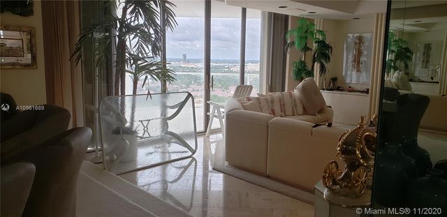 a view of a hallway with wooden floor and dining room view