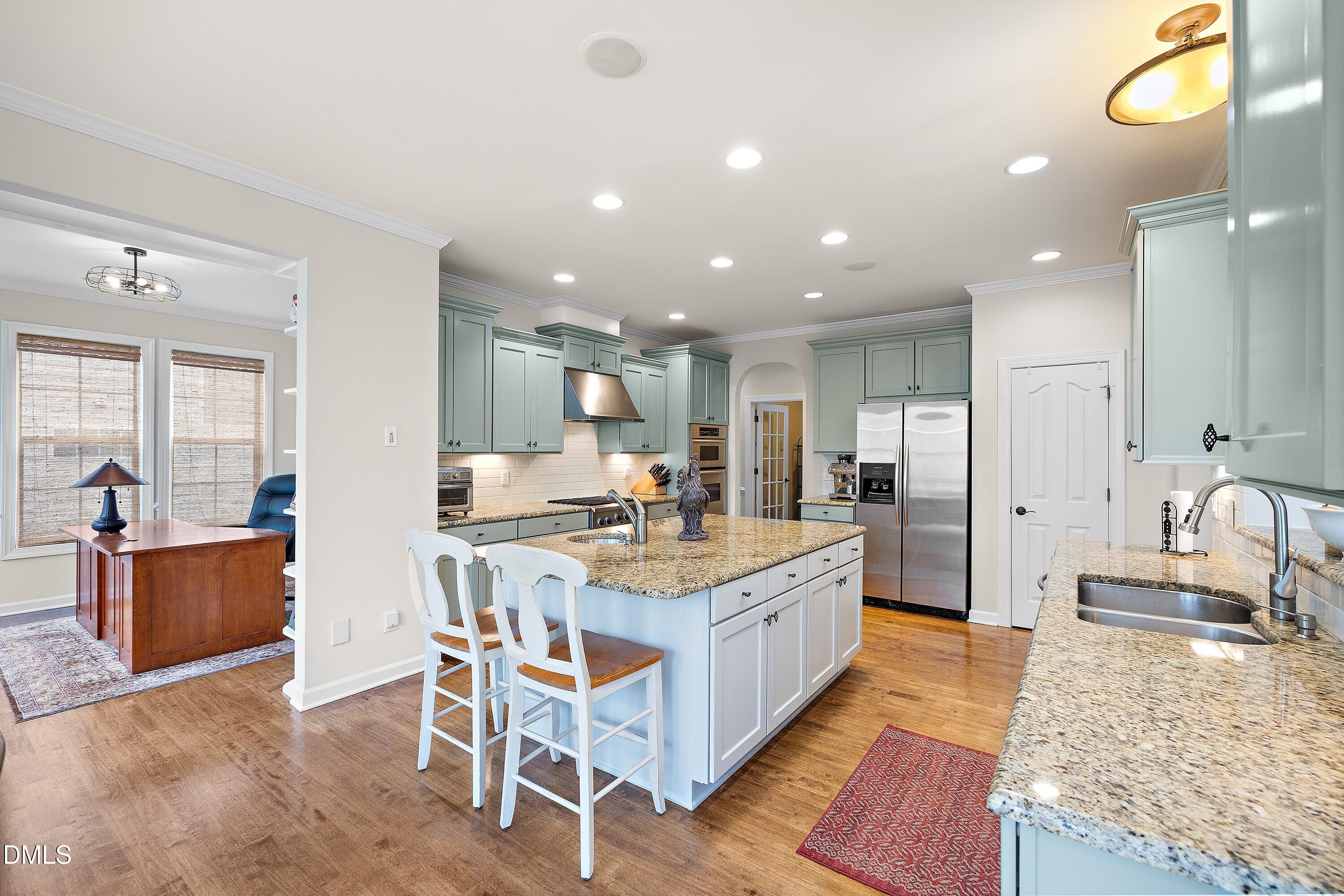 701 Royal Tower Way Cary, NC 27513 - Photo 14 of 82 a large kitchen with kitchen island a island a sink a stove a dining table and chairs