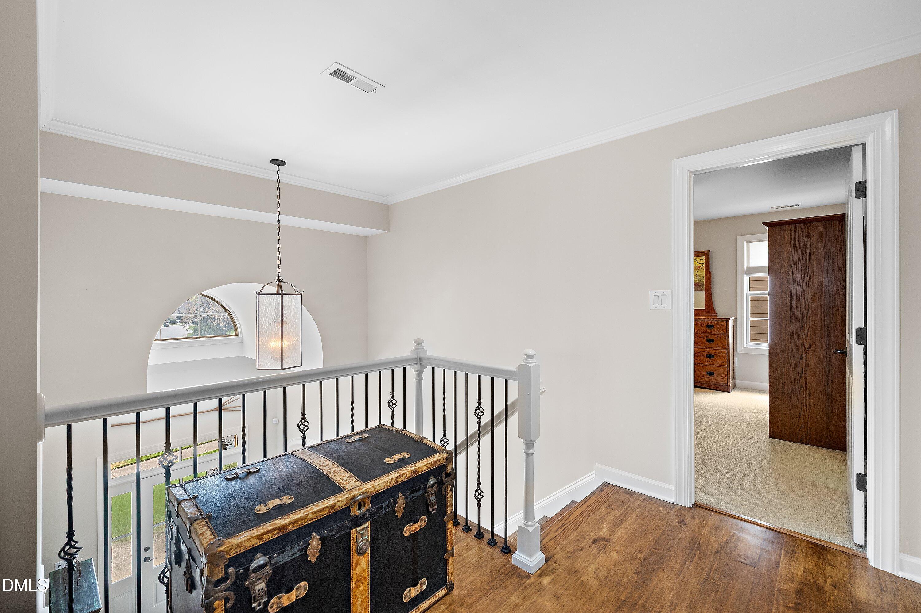 701 Royal Tower Way Cary, NC 27513 - Photo 41 of 82 a view of a hallway with wooden floor and stairs