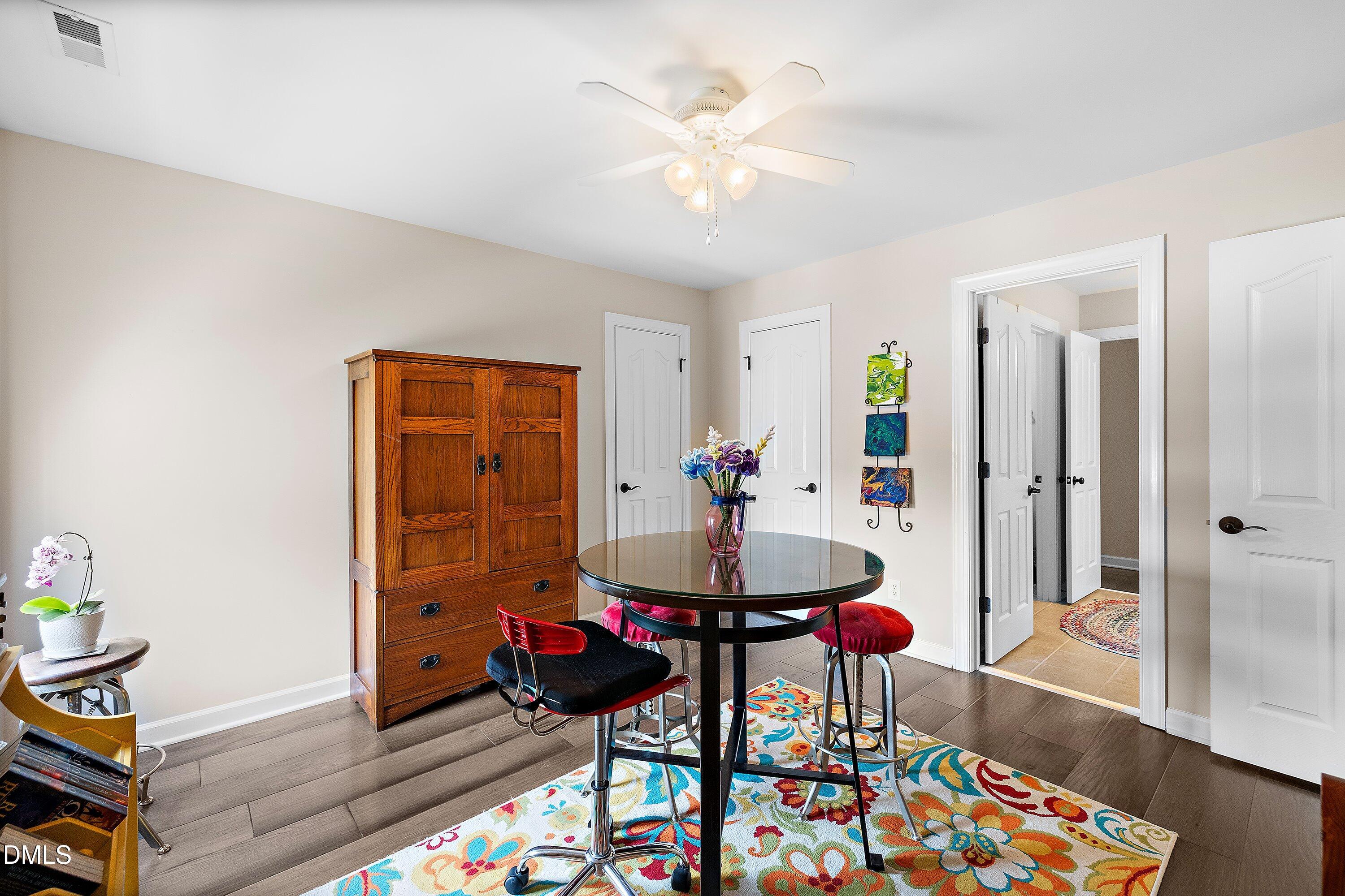 701 Royal Tower Way Cary, NC 27513 - Photo 59 of 82 a living room with dining table and paintings on the wall with wooden floor