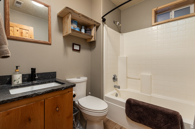 1505 West Elk Ridge Drive Alton, UT 84710 - Photo 33 of 53 Full bath featuring shower combination, vanity, a textured ceiling, wood finished floors, and a textured wall