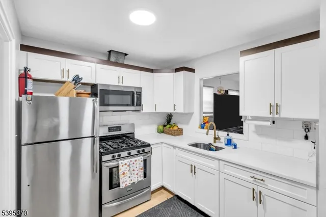 a kitchen with appliances a sink and cabinets