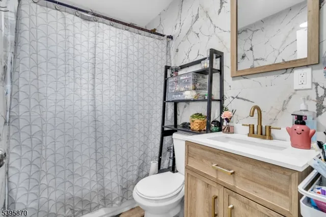 a bathroom with a sink a toilet and shower curtain