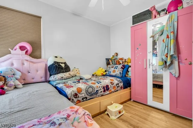 a bedroom with bed and wooden floor