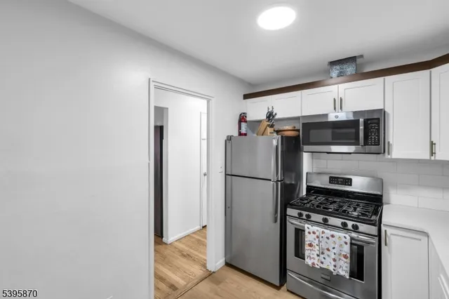 a kitchen with stainless steel appliances a refrigerator a stove a microwave a sink and cabinets