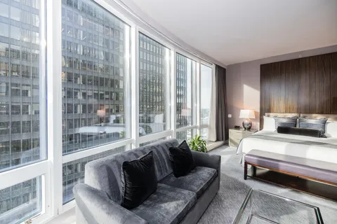 a bedroom with furniture and a large window