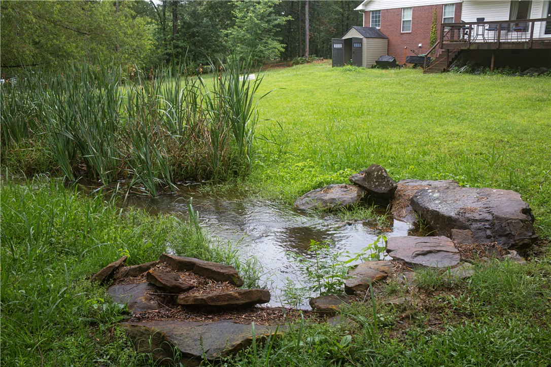 164 Park Road Russellville, AR 72802 - Photo 35 of 35 Natural water feature with surrounding large stones, tall aquatic plants, and expansive grassy areas
