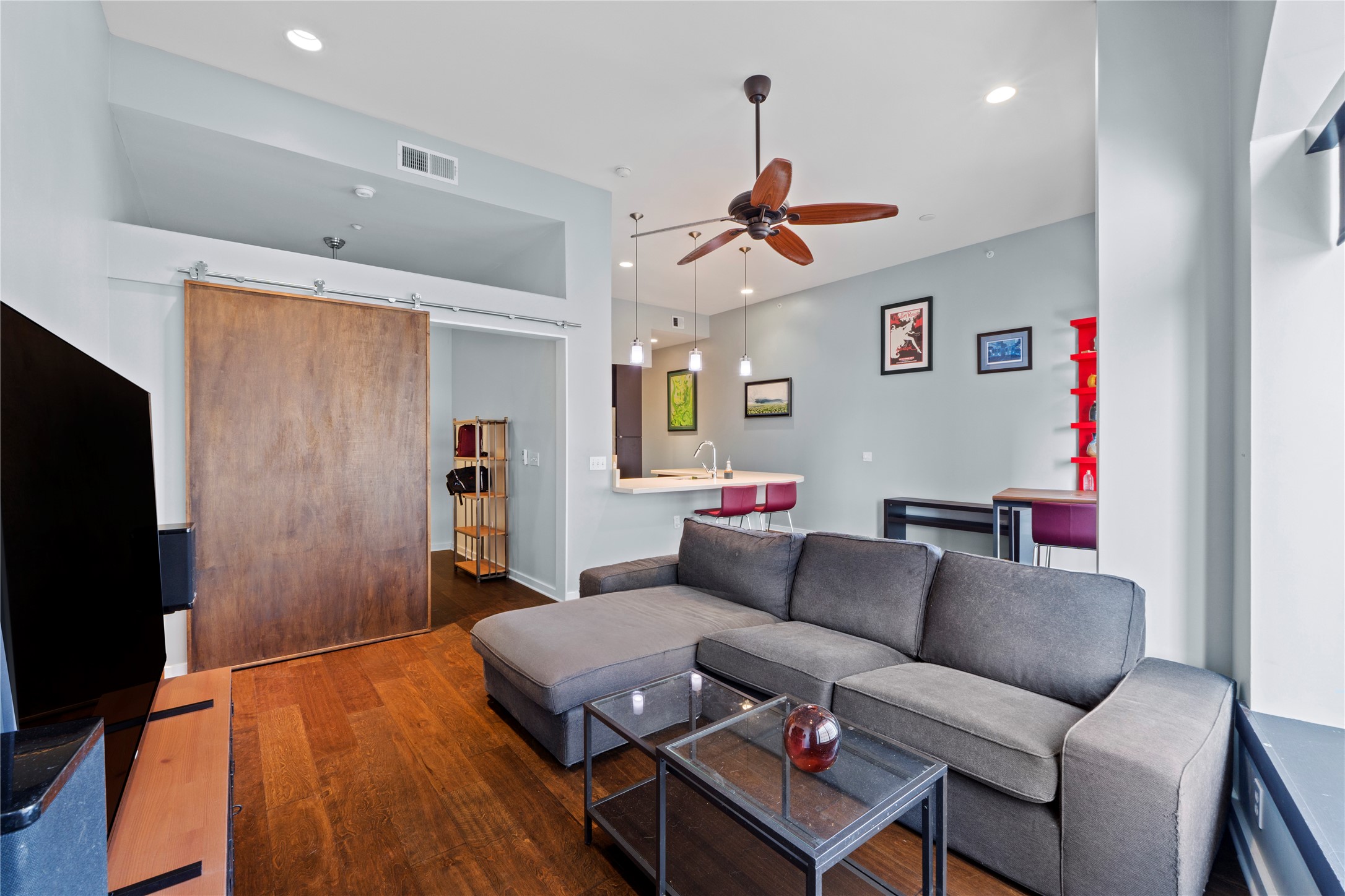 507 Sabine Street, Unit 509 Austin, TX 78701 - Photo 12 of 23 Living area featuring dark wood finished floors, a barn door, recessed lighting, and a ceiling fan