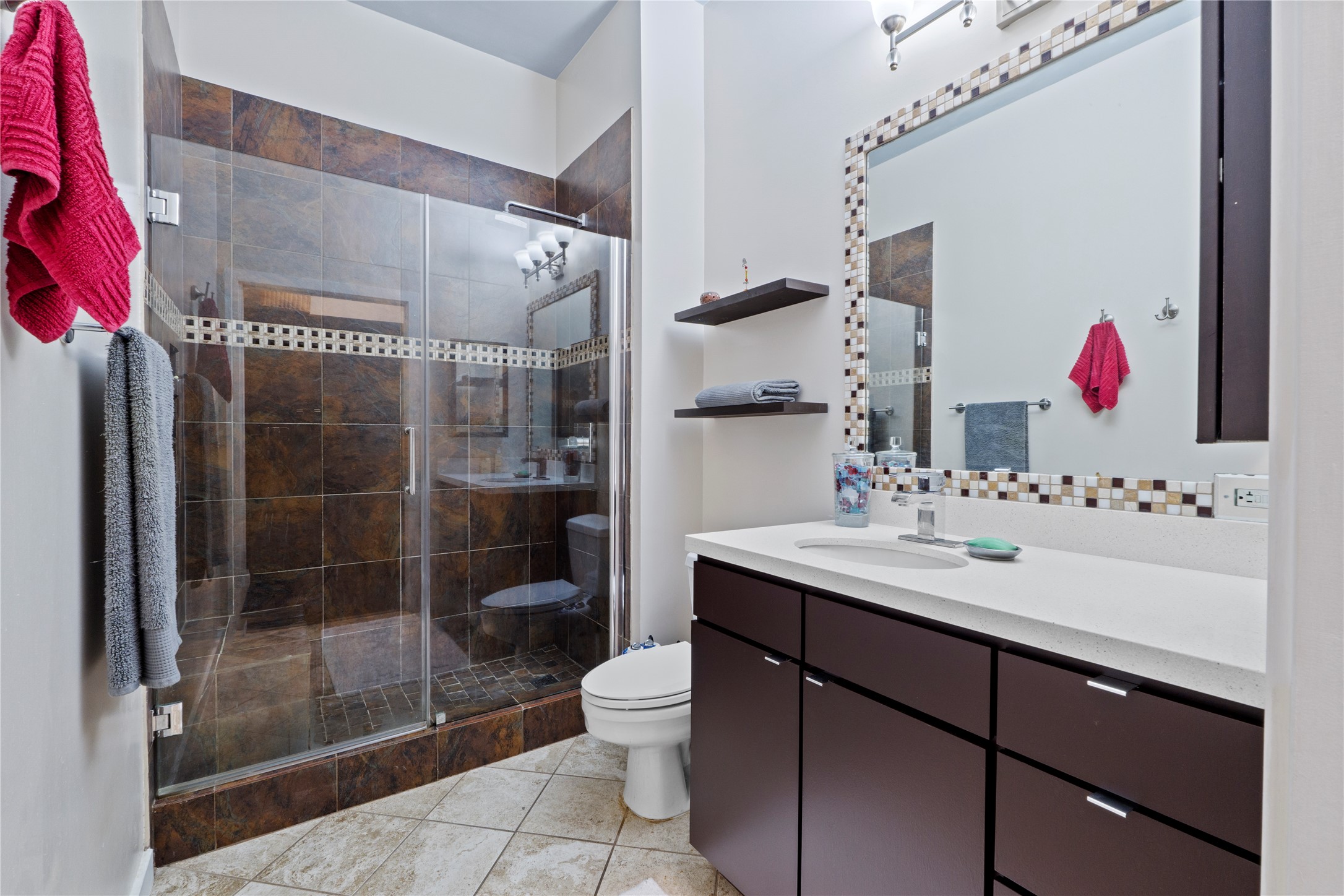 507 Sabine Street, Unit 509 Austin, TX 78701 - Photo 18 of 23 Bathroom featuring vanity, light tile patterned floors, and a stall shower