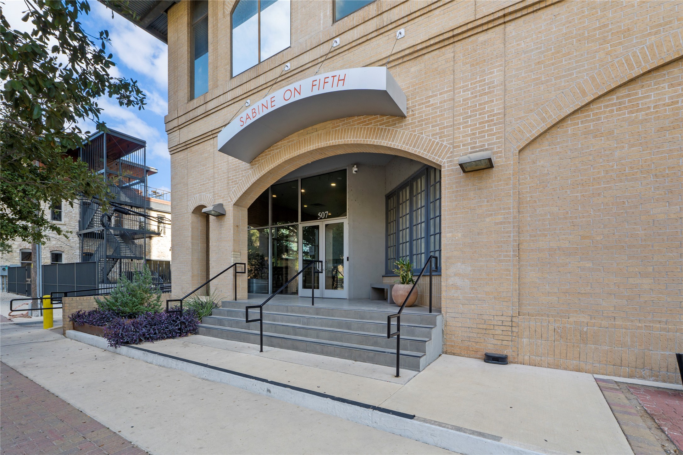507 Sabine Street, Unit 509 Austin, TX 78701 - Photo 22 of 23 View of exterior entry with french doors and brick siding
