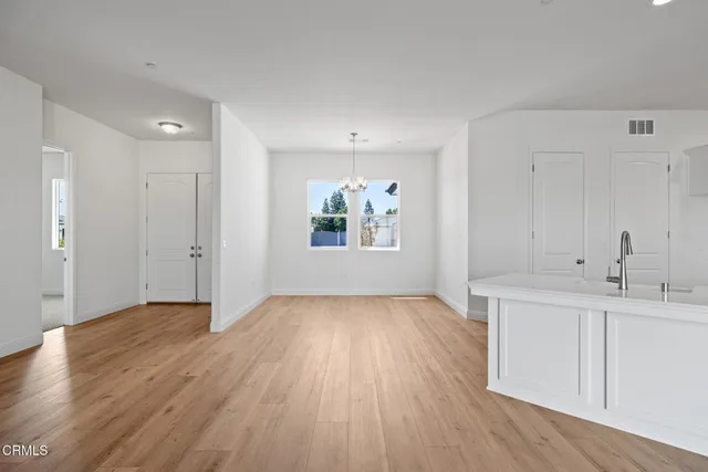 a view of empty room with wooden floor and ceiling fan