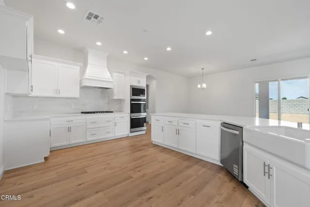a kitchen with kitchen island white cabinets appliances and counter space