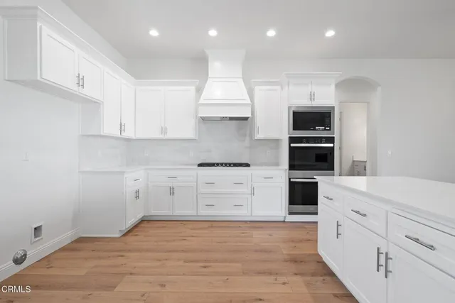 a kitchen with white cabinets and sink