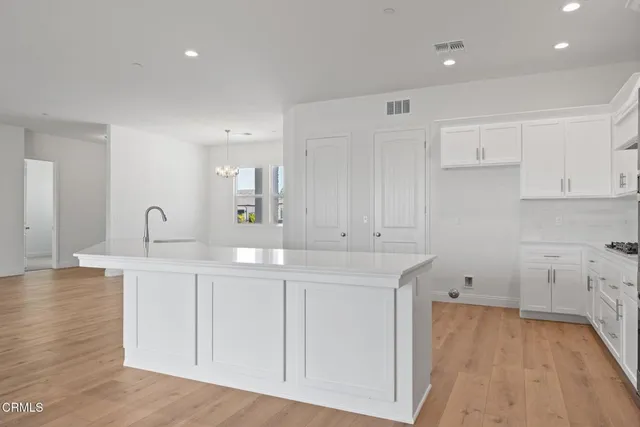 a kitchen with wooden floors and white cabinets