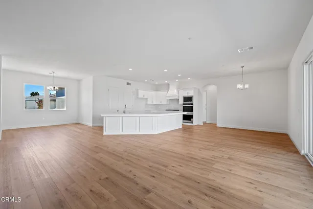 a view of large kitchen with a sink refrigerator and window
