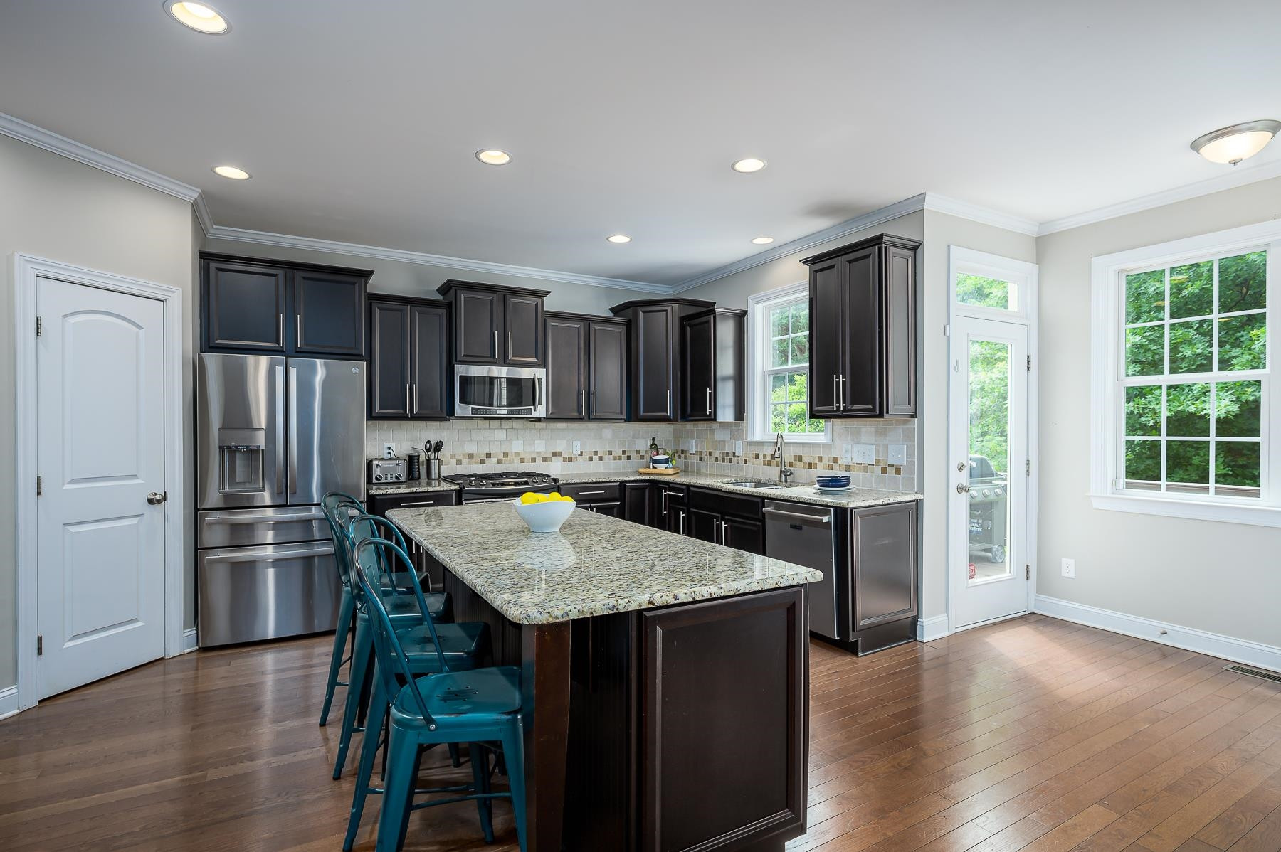 413 Mickey Lane Cary, NC 27513 - Photo 13 of 35 a kitchen with kitchen island granite countertop wooden floors appliances and center island