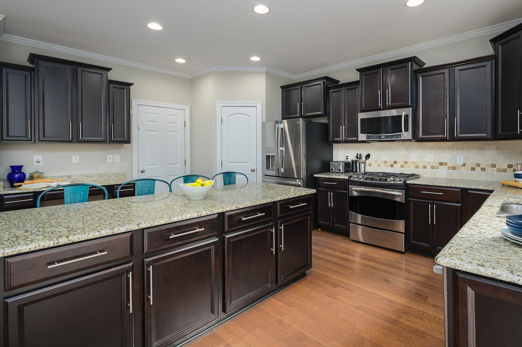 413 Mickey Lane Cary, NC 27513 - Photo 14 of 35 a kitchen with kitchen island granite countertop stainless steel appliances and wooden cabinets