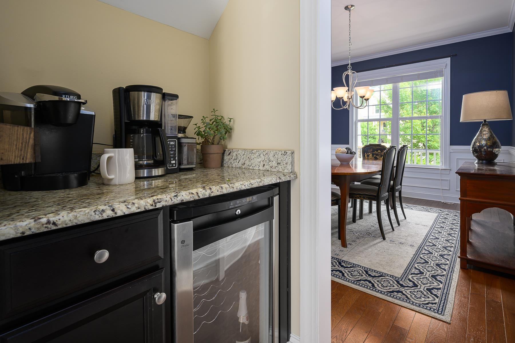413 Mickey Lane Cary, NC 27513 - Photo 17 of 35 a kitchen with granite countertop a stove a sink dining table and chairs with wooden floor