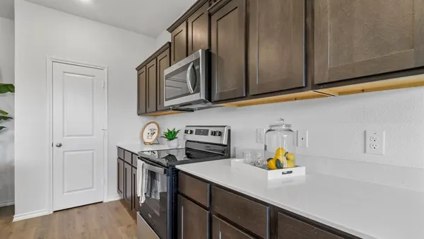 a kitchen with stainless steel appliances a sink a table and chairs in it