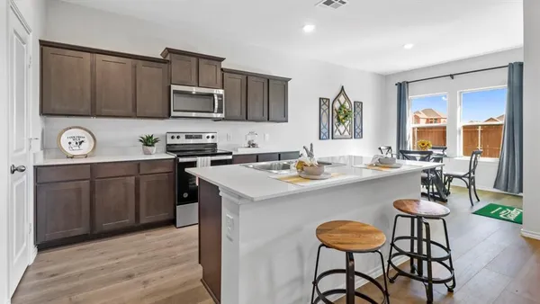 a kitchen with stainless steel appliances granite countertop a sink a stove and cabinets