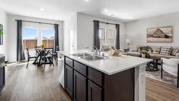 a kitchen with stainless steel appliances a sink a stove a refrigerator cabinets and dining table