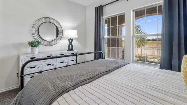 a bed sitting in a bedroom next to a window
