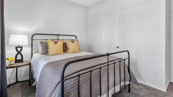 a bedroom with a bed and a large mirror next to a window