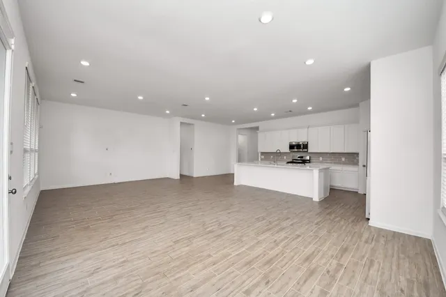 a large kitchen with stainless steel appliances granite countertop a stove a sink and a refrigerator