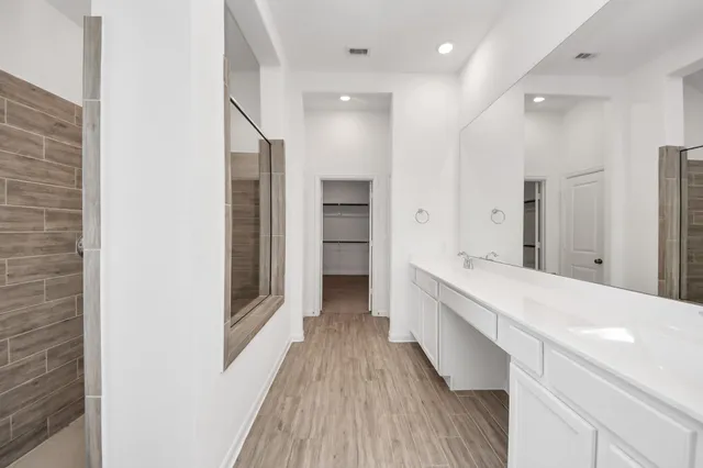 an empty room with chandelier fan and windows