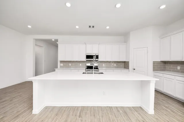 a view of kitchen with stove and cabinets