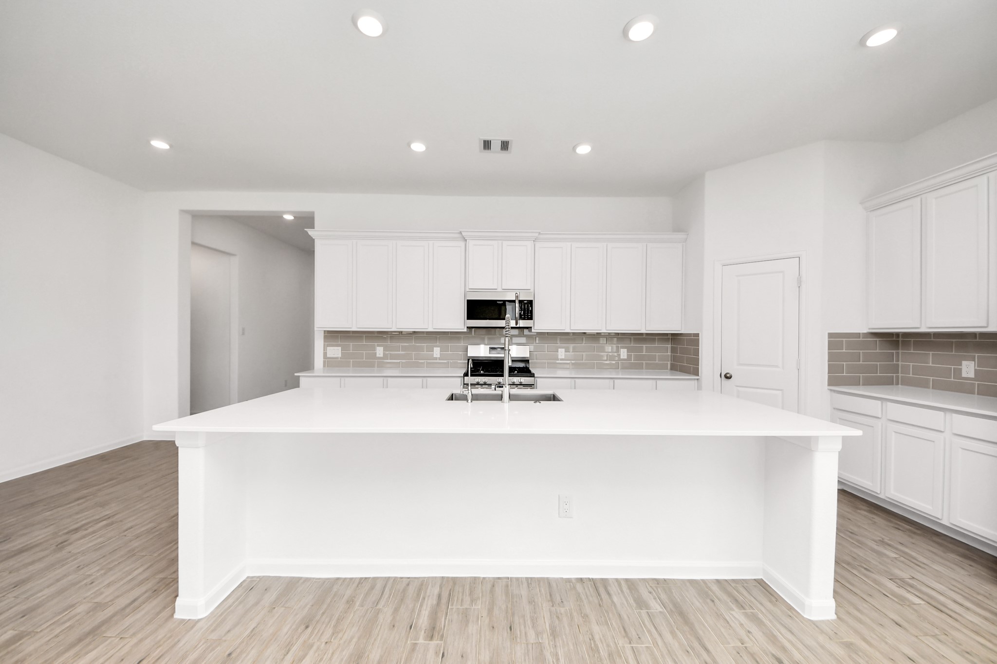 17770 Misty Brook Lane Conroe, TX 77302 - Photo 9 of 50 a large white kitchen with wooden floor and stainless steel appliances