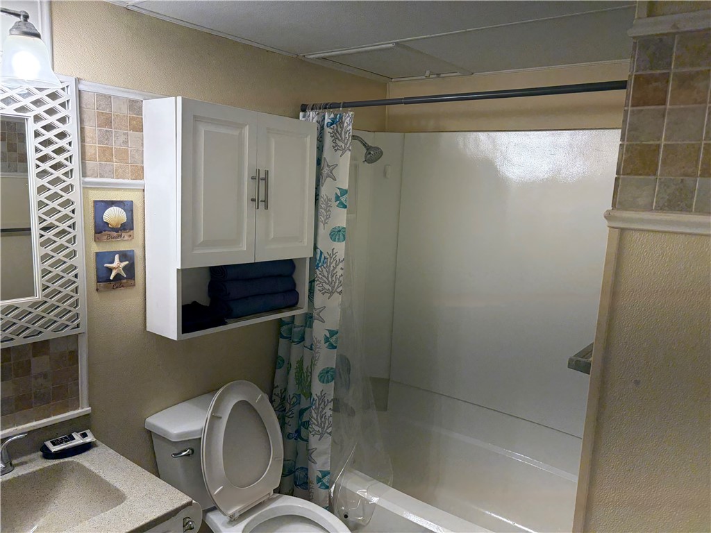 3938 Surfside Boulevard Corpus Christi, TX 78402 - Photo 8 of 12 a bathroom with a granite countertop sink toilet and shower