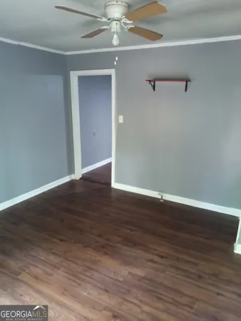 a view of an empty room with wooden floor