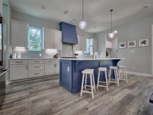 a kitchen with kitchen island granite countertop a sink a counter space appliances and cabinets