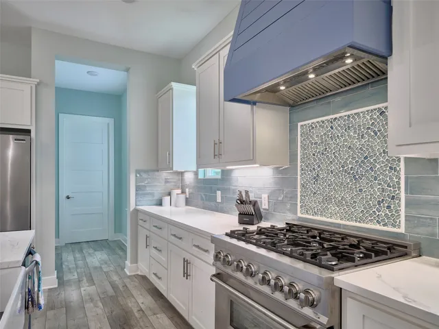 a kitchen with white cabinets and appliances