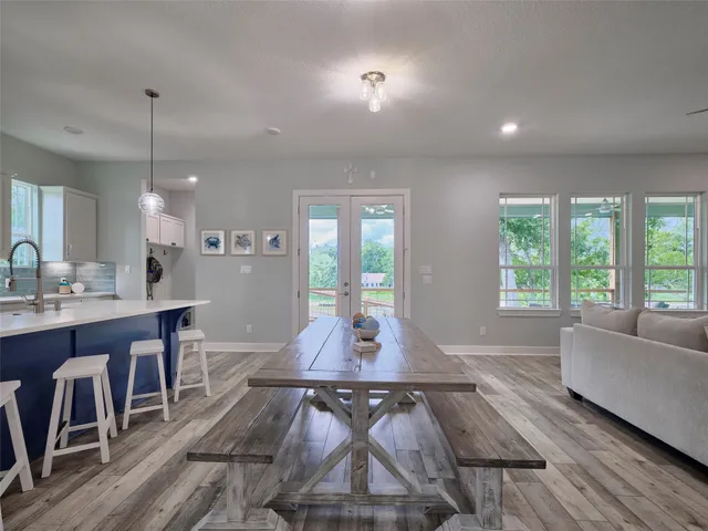 a living room with furniture a wooden floor and a chandelier