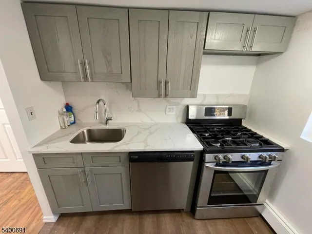 a kitchen with a sink a stove and cabinets
