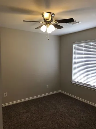 a view of a livingroom with a chandelier fan and a window