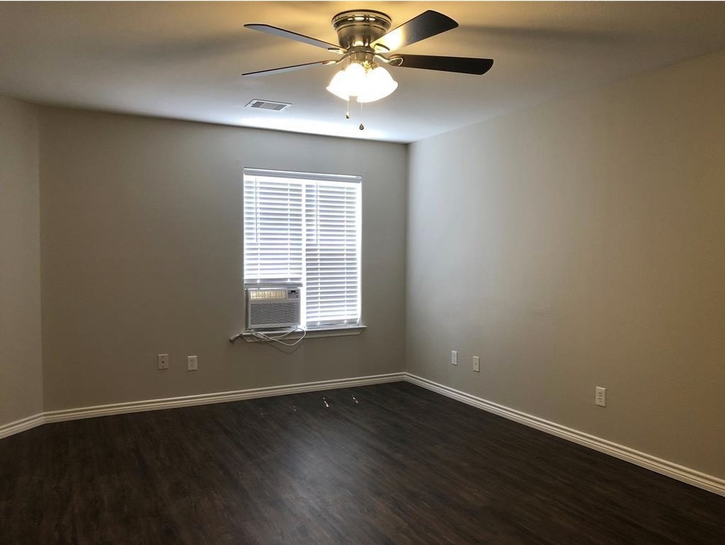 212 Gulf Pump Road, Unit C Crosby, TX 77532 - Photo 7 of 14 an empty room with wooden floor chandelier fan and windows