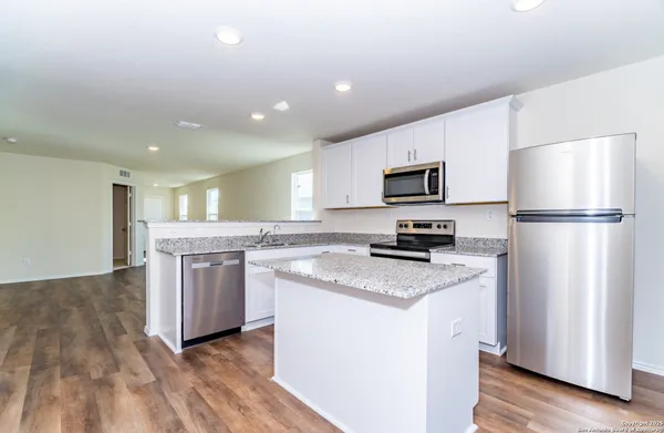 a kitchen with a refrigerator and a stove top oven