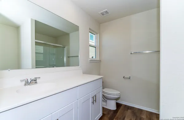 a bathroom with a sink a toilet and mirror