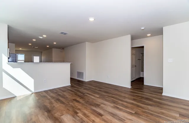 a view of a big room with wooden floor and staircase