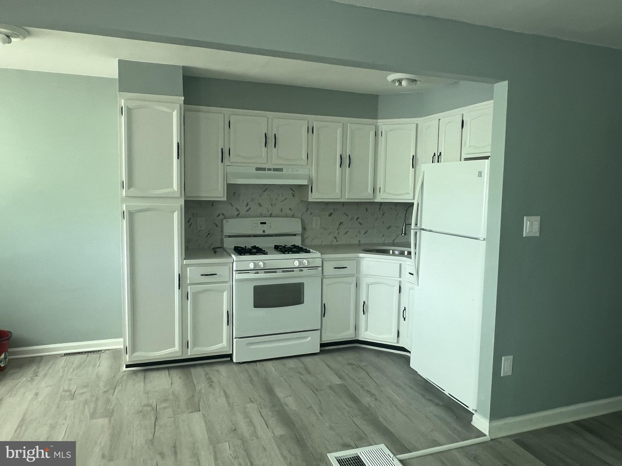 6526 Keystone Street Philadelphia, PA 19135 - Photo 4 of 7 a kitchen with white cabinets and white appliances