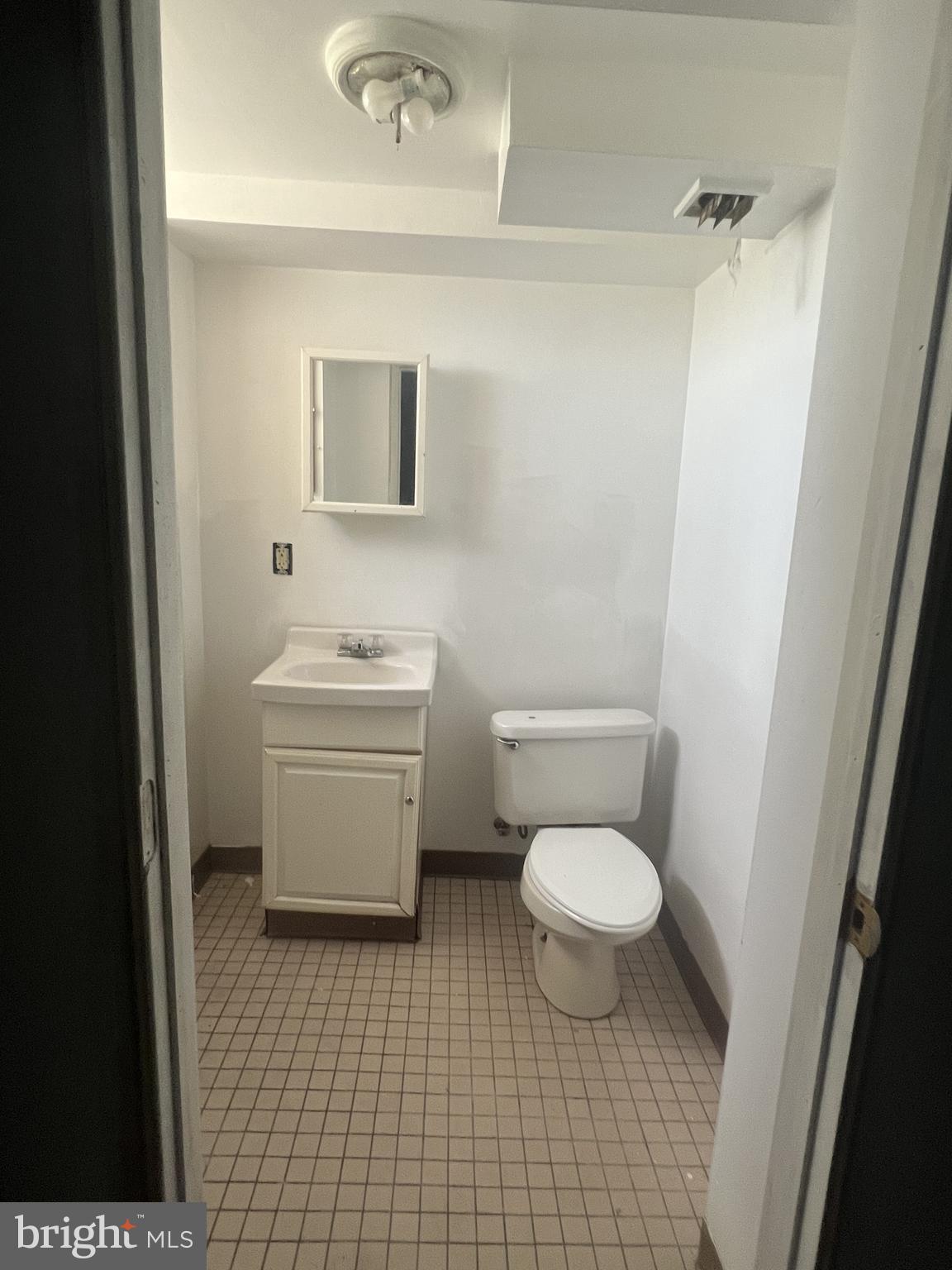 6526 Keystone Street Philadelphia, PA 19135 - Photo 6 of 7 a bathroom with a toilet a sink and a mirror