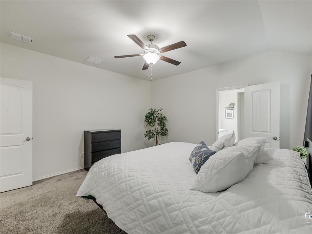 4517 Ashmark Road Aubrey, TX 76227 - Photo 11 of 26 a bedroom with a bed and a ceiling fan